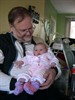 Grandpa Larry holding Ava with the booties I crocheted for her