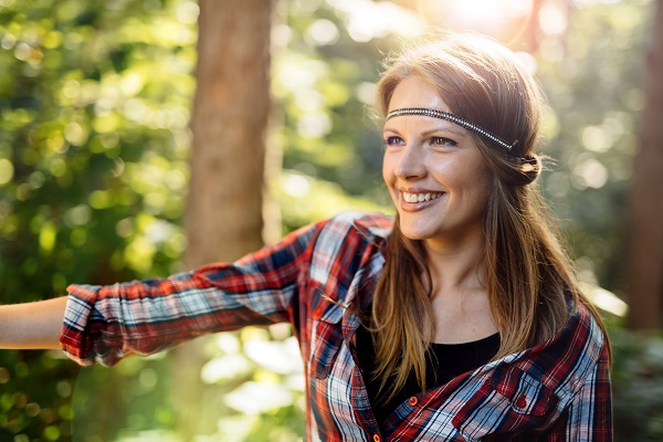 Beautiful smiling Norwegian woman posing all alone standing in a green forest