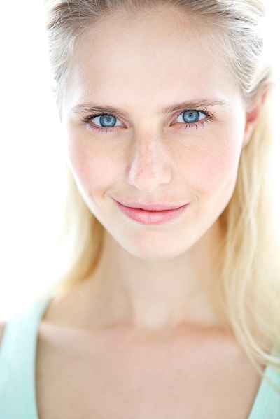 Confident young Norwegian girl smiling directly in the camera with her hair in the back