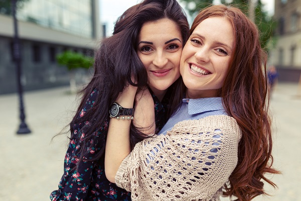 Carefree smiling Czech sisters hugging and having fun together