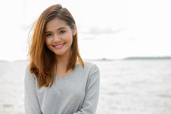 Young beautiful Thai woman against a scenic view of the lake