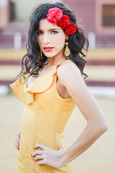 Charming young Italian girl wearing a yellow dress posing for the camera