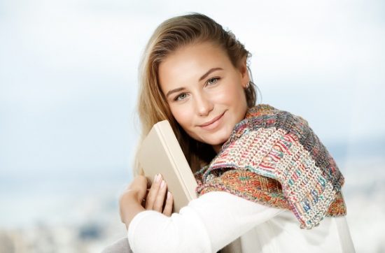 Young beautiful Belarusian girl sitting with a book in her hands