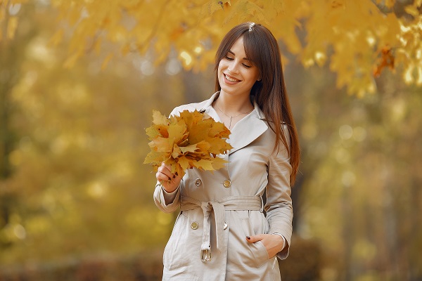 Charming beautiful Lithuanian woman walking with a bouquet of yellow leaves all alone