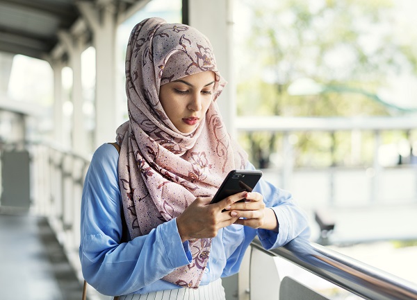 Serious Egyptian lady looking into her smartphone