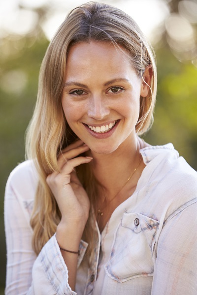 Smiling Estonian girl touching her hair looking directly in the camera