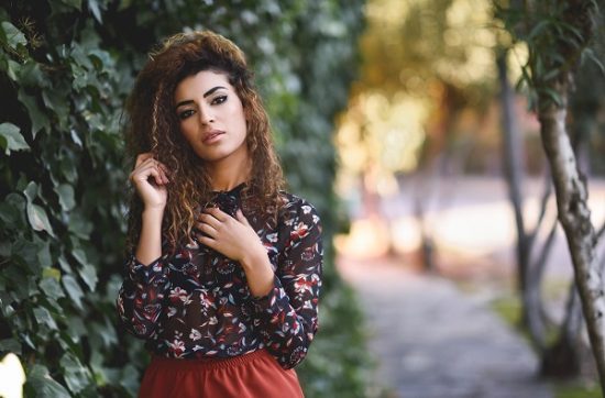 Beautiful young Turkish woman with a black curly hairstyle posing for the photo