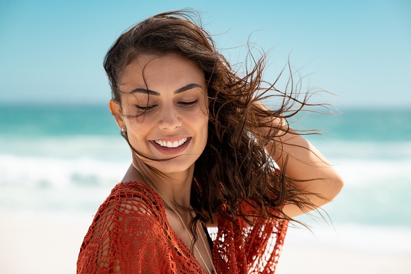 Attractive Panamanian woman standing with her eyes closed on a beach