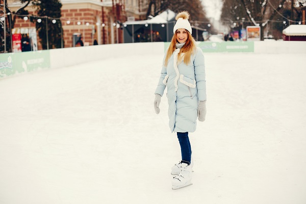 Young blonde Serbian woman spending her free time on a skating rink surrounded by ice and snow